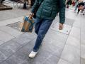 Un hombre camina con una bolsa con compra de un centro comercial