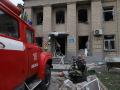 Los rescatistas descansan frente al edificio de maternidad de dos pisos destruido en la ciudad de Vilniansk, en la región sur de Zaporiyia