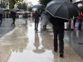 Personas caminan por la calle con paraguas, a 13 de diciembre de 2022, en Madrid