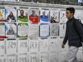 Un joven pasa junto a los carteles electorales de los candidatos que se postulan en las elecciones legislativas tunecinas