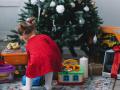 Una niña recoge sus regalos de debajo del árbol
