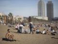 Varias personas disfrutan del buen tiempo en las playas de Barcelona este lunes debido a las inusuales altas temperaturas en esta época del año