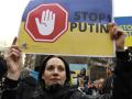 Una manifestante con una pancarta en contra de Putin