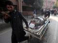 Un hombre traslada en camilla a un herido en el atentado en una mezquita de Pakistán