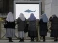 Varias religiosas observan el helicóptero de Benedicto XVI el día de su renuncia