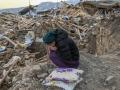 Una mujer llora mientras se sienta sobre los escombros de su casa derrumbada en la aldea de Yaylakonak en el distrito de Adiyaman