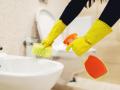 Una mujer limpia el baño de una casa