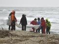 Los bomberos italianos y la Cruz Roja se reúnen en el lugar donde los cuerpos de los migrantes llegaron a la costa después de un naufragio