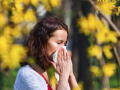 Una mujer sufre los efectos de la alergia en un parque
