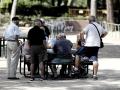 Varios pensionistas juegan al dominó en un parque de Madrid.