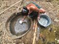 Una mujer recoge agua de un pozo en el río Cihoe