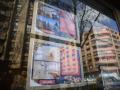 Carteles de viviendas en venta en el escaparate de una inmobiliaria en Madrid.