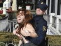 MADRID, 20/11/2022.- Una activista de Femen es interceptada por la policía mientras irrumpe en la concentración Movimiento Católico Español, convocada este domingo en Madrid en protesta por la Ley de Memoria Democrática. EFE/ Víctor Lerena
