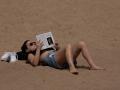Una mujer toma el sol en la playa de la Barceloneta