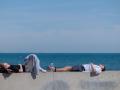 Dos personas descansan al sol en la playa de la Malvarrosa durante este segundo día de mayo en el que se mantienen las altas temperaturas