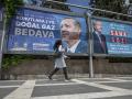 Una mujer siria pasa junto a vallas publicitarias sobre la campaña electoral en Turquía