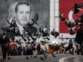 Personas pasan un retrato del presidente turco Recep Tayyip Erdogan y una bandera turca en Bursa, Turquía