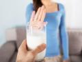 Close-up Of A Woman Rejecting Glass Of Milk At Home
