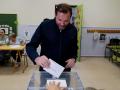 El alcalde de Valladolid, Óscar Puente, deposita su voto después de esperar que le trajeran el DNI olvidado en su casa
