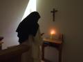 Una monja cartuja orando en su eremitorio