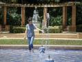 Una mujer se refresca en una fuente en plena ola de calor en Sevilla este domingo