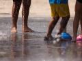 Varias personas juegan en el agua para refrescarse en Madrid Rio