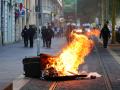 Policías antidisturbios franceses montan guardia detrás de un basurero quemado en Marsella