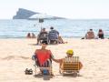 Numerosas personas se bañan y toman el sol en la playa de Poniente, Benidorm, Alicante