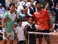 Carlos Alcaraz y Novak Djokovic posan en la red durante las semifinales de Roland Garros