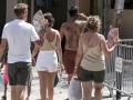 Varios turistas combaten el calor con abanicos este martes en el mercadillo de verano de la plaza de la Explanada de Mahón (Menorca)