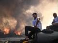 Dos hombres sentados en su camioneta mientras los incendios forestales devoran la isla de Rodas