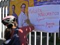 Un ciclista cuelga una pancarta en las rejas del complejo deportivo donde la víspera fue asesinado el candidato presidencial ecuatoriano Fernando Villavicencio