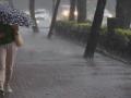 Una mujer camina por la acera bajo una intensa lluvia en Valencia