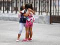 Dos niñas se abrazan en la puerta del colego