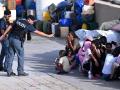 Un policía italiano interactúa con niños migrantes rescatados que tiran pompas en Lampedusa