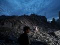 -FOTODELDÍA- EA6592. CIUDAD DE GAZA (---), 07/10/2023.- Menores inspeccionan los alrededores destruidos de la Torre Palestina después de que aviones de combate israelíes la atacaran en la ciudad de Gaza, el 7 de octubre de 2023. A principios de este mismo sábado, se lanzaron andanadas de cohetes desde la Franja de Gaza en un ataque sorpresa contra Israel reivindicado por el movimiento islamista Hamás. En una declaración televisada, el primer ministro israelí dijo que el país está en guerra. EFE/ Mohammed Saber