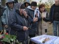 Familiares y amigos lloran ante un ataúd en la aldea de Groza, Ucrania