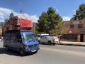 Un vehículo se desplaza, ataviado con colchones y la bandera marroquí
