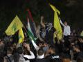Varios manifestantes levantan banderas palestinas y de Hezbolá durante una manifestación en el sur del Líbano