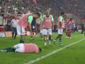 Juankar, futbolista del Panathinaikos, tumbado en el suelo tras lanzarle aficionados rivales un petardo
