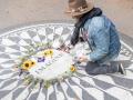 Un fan que le está rindiendo homenaje a John Lennon en la placa del Central Park en su honor