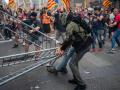 Un hombre arrastra una valla durante unos altercados en la comisaría de la Policía Nacional de la via Layetana