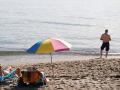 Varias personas disfrutan tomando el sol en la playa de la Malagueta