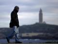 Un hombre camina por el paseo marítimo de La Coruña