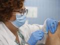 Una enfermera vacuna inocula una vacuna contra la gripe y la covid