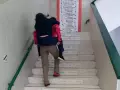 Madre subiendo a sus hijos por las escaleras