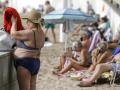 Numerosas personas disfrutan del buen tiempo en la playa de Levante de Benidorm, donde las temperaturas llegaron a superar los 25º
