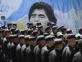 Policías resguardan el orden durante las manifestaciones opositoras contra Milei con un mural del futbolista Diego Maradona de fondo