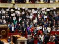 Los parlamentarios de la coalición de izquierda NUPES sostienen carteles contra la ley de inmigración