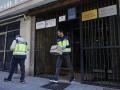 Agentes de la Policía Nacional portan objetos del domicilio del canónigo asesinado en Valencia